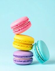 Colorful macarons float mid-air on pastel blue background. Pink, yellow, purple, and turquoise cookies in soft light. Minimal, playful, elegant dessert display.