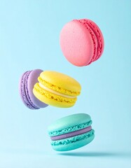 Colorful macarons float mid-air on pastel blue background. Pink, yellow, purple, and turquoise cookies in soft light. Minimal, playful, elegant dessert display.