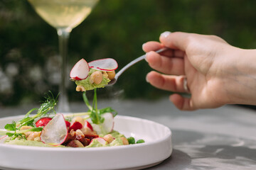 Person eating healthy salad with fresh ingredients