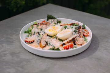 Delicious caesar salad with grilled chicken and eggs
