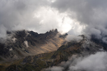 Atmospheric misty rock valley at sunset on the Tour du Mont Blanc route in the French Alps, ideal for travel and nature themes.
