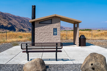 A metal bench faces the public restroom at Jackson Creek Fish Camp in Washington, USA