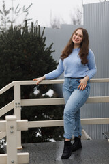 A girl in a park in winter near white railings