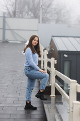 A girl in a park in winter near white railings