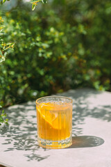 Refreshing orange drink with ice outdoor in daylight