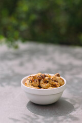 White bowl of roasted cashew nuts on table
