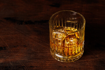 A classic whiskey glass filled with golden amber whiskey