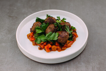 Cooked meatballs with sauce and fresh parsley