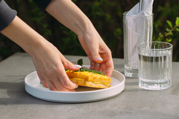 Woman serving a sandwich on a white dish