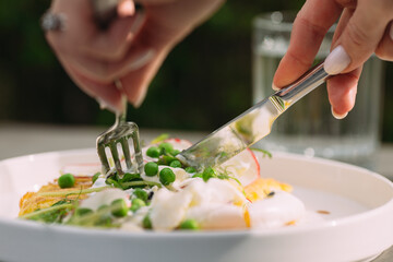 Person eating healthy meal with fork and knife
