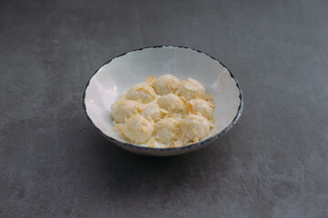 Creamy dessert with almonds in rustic bowl