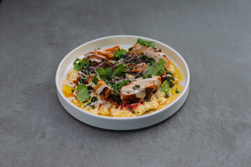 Gourmet chicken dish with creamy polenta and fresh herbs