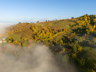 Sunrise over rolling green hills with low lying fog creating a dreamy and peaceful landscape view