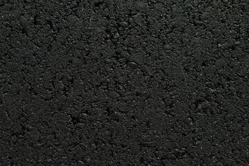New dark black asphalt background. Closeup. Empty place for text. Top down view.