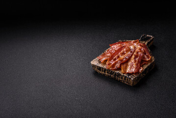 Fried pork bacon slices or strips as a breakfast ingredient. Fried bacon