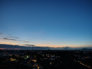 Naklejka premium La ciudad despierta lentamente, envuelta en tonos dorados y rosados que anuncian un nuevo comienzo. Cada rayo de sol se refleja en los edificios, convirtiendo lo cotidiano en un instante mágico.