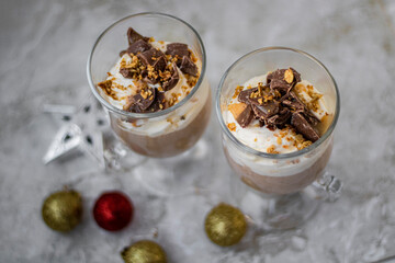 Holiday chocolate mousse with whipped cream and festive decorations from above