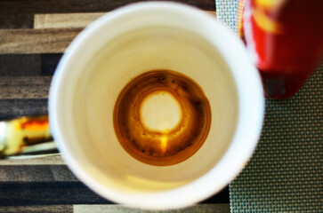 Top view of coffee cup with dark grounds inside after drinking