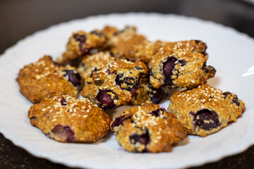 Homemade blueberry cookies sprinkled with sesame seeds on a white plate