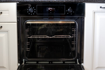Obraz premium The open door of a new oven with visible racks, ready for cooking