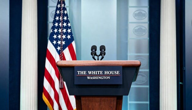White House podium with microphones and U.S. flag in formal setting.