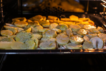 Sliced potatoes are baked in a hot oven. It turns out a delicious dinner