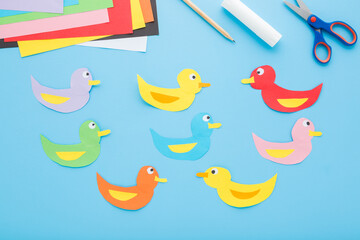 Created and glued colorful duck shapes. Scissors, glue stick, pencil and application paper on light...