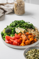 Vibrant vegan buddha bowl with quinoa, roasted vegetables, and fresh greens. Vegetable recipes.