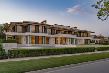Fototapeta premium sprawling contemporary mansion with floor-to-ceiling windows and manicured landscaping