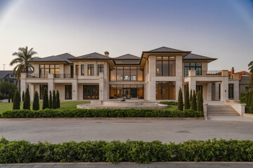 Obraz premium sprawling contemporary mansion with floor-to-ceiling windows and manicured landscaping