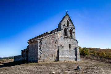 Low angle view of the ancient Romanesque Church of Saint Martin on a hill in Quintanilla de la Berzosa, Palencia, Spain