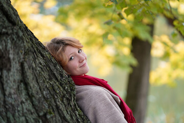 Portrait of a Girl in an Autumn Park in Coat and Red Scarf