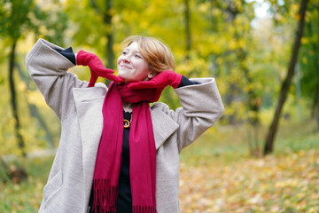 Portrait of a Girl in an Autumn Park in Coat and Red Scarf