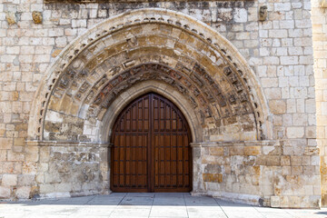 Naklejka premium Gothic portal with sculpted archivolts on the facade of the historic Church of San Miguel in Palencia, Spain
