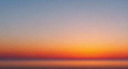 Abstract blurred gradient of a sunset sky over water, showcasing warm orange and red hues blending into cool blue.