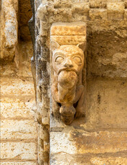 Grotesque Romanesque corbel of a monster devouring a sinner at the Church of San Martin in Fromista, Spain