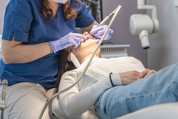 The dentist cleans the patient's mouth.