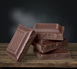 Tasty sweet Chocolate bar pieces on desk