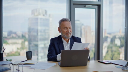 Successful entrepreneur reading contract enjoying agreement in office closeup.