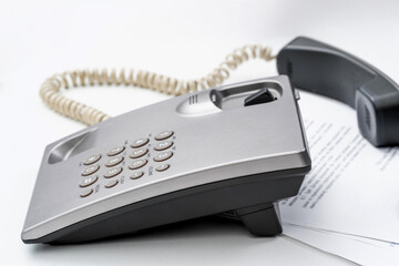 Overworked secretary managing tasks and phone calls in a busy office environment during late hours