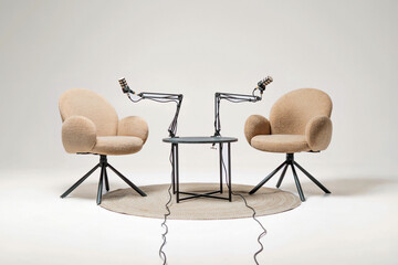 Podcast setup with cozy chairs and microphones in a simple studio environment for engaging discussions