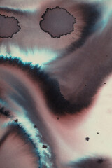 Abstract background of two-component calligraphy ink runs and blooms on paper 
