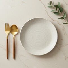 A rustic speckled plate with gold cutlery and eucalyptus sprig isolated on white background