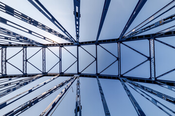 Bolts and nuts on metal plates of steel structure of heavy duty straight crossbar of frame and bridge support