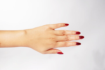 A hand with red nails held open and pointing down in front of a white background