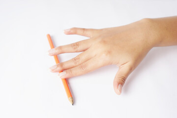 A hand grasping an orange pencil against a white background