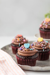 Chocolate Cupcakes with Chocolate Buttercream Icing with Valentine Day Sprinkles on a White Background with Copy Space