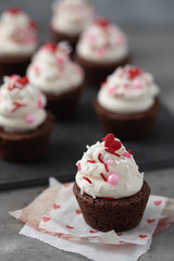 Close Up of a Brownie Round with Vanilla Buttercream Icing and Valentine Sprinkles with More Frosted Brownines in the Background on a Tray