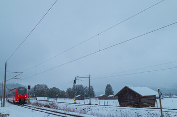 Zug fährt durch schneebedeckte Winterlandschaft Alpen Bayern