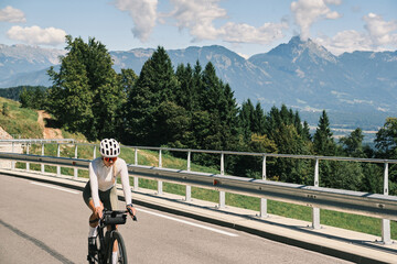 A cyclist enjoys a scenic mountain bike ride on a sunny day. Stunning mountain backdrop, perfect for active lifestyle, travel, and adventure themes. High-quality image ideal for print and web. © KatyaPulka